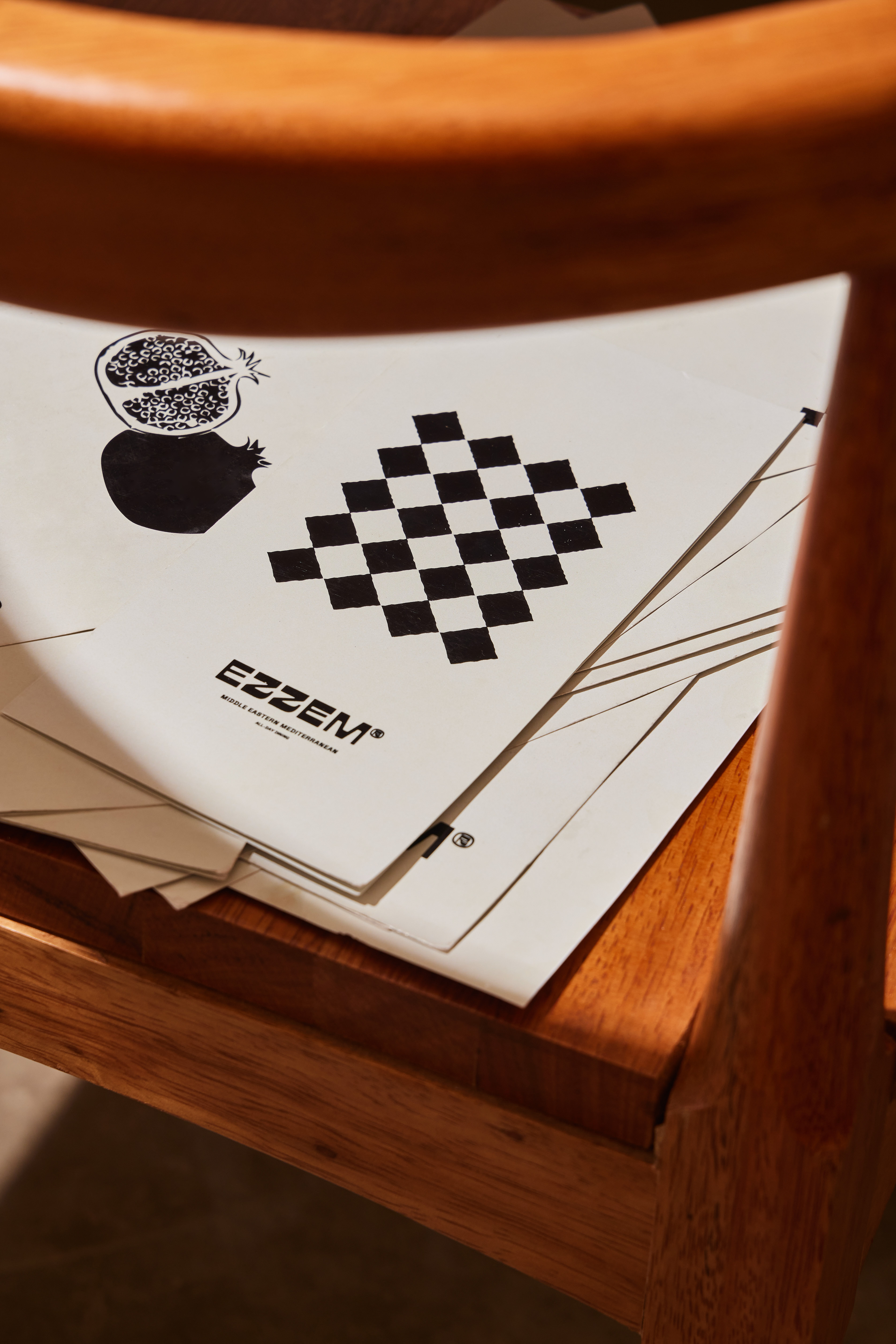Papelería de EZZEM sobre una silla de madera